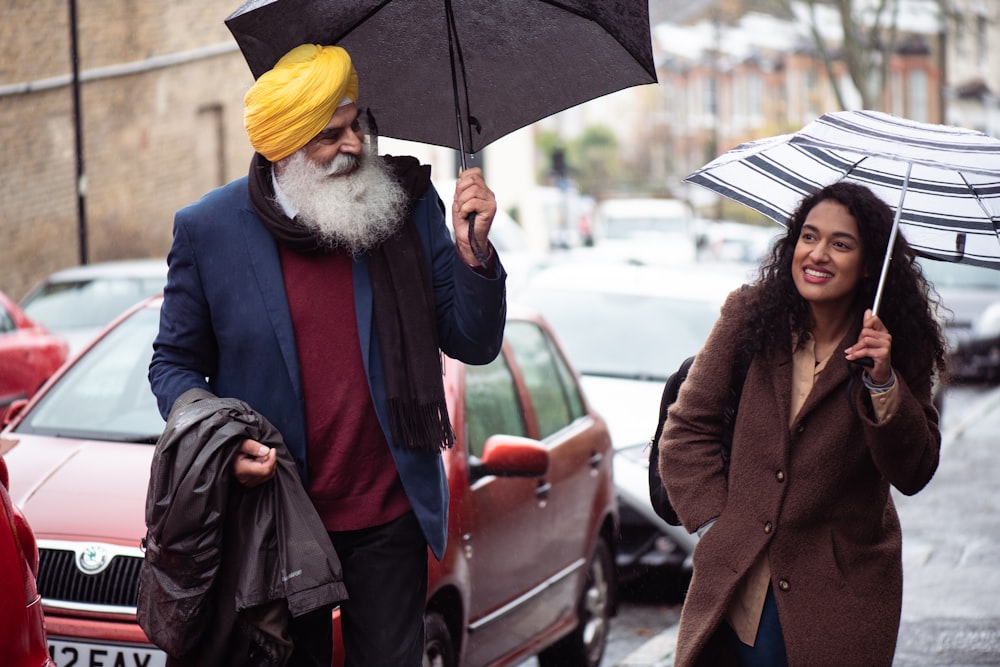 a man with a yellow turban and a woman with a black umbrella