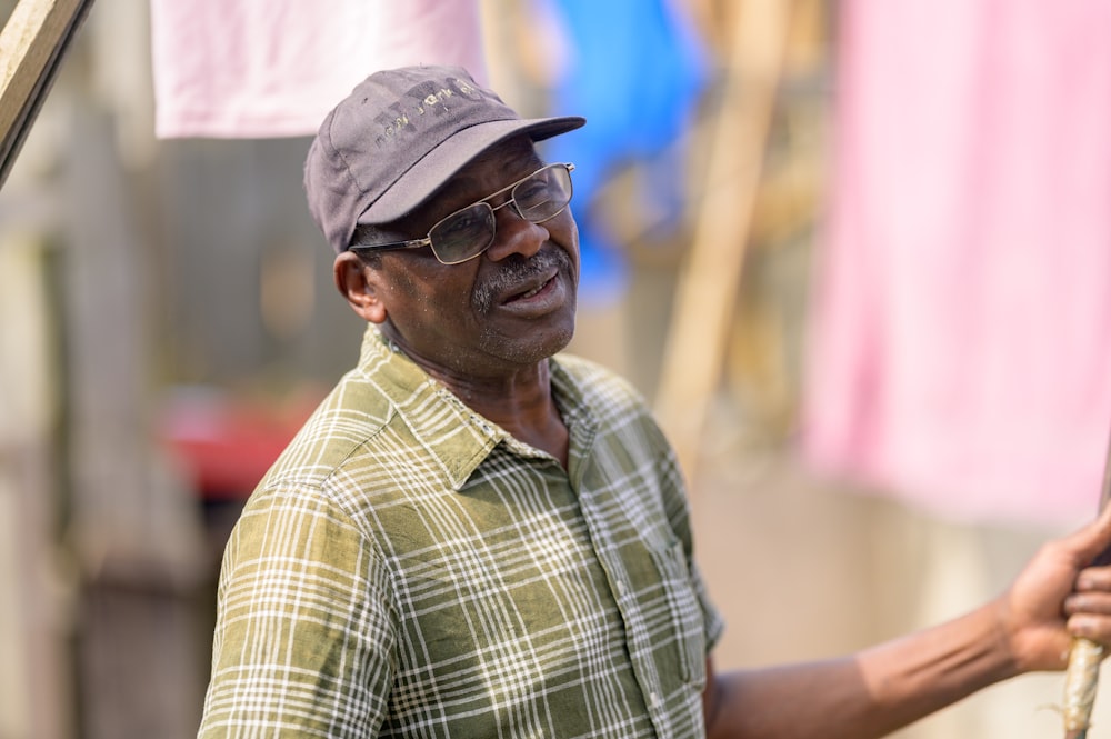 a man wearing a hat and glasses holding a baseball bat