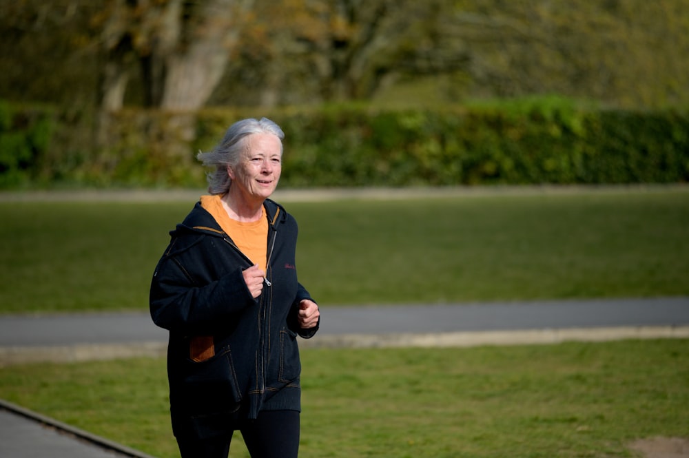 an older woman is jogging in the park