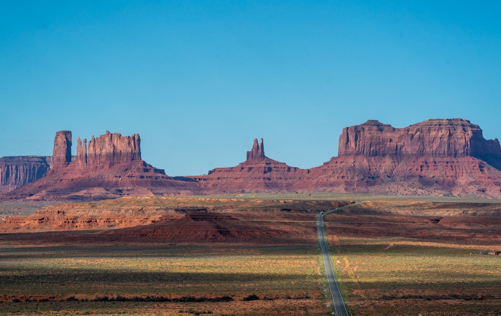 a road in the middle of a desert with mountains in the background