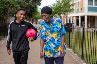 A coach and adolescent walking outdoors, sharing a thoughtful moment.