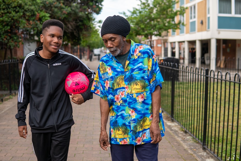 a couple of men standing next to each other on a sidewalk