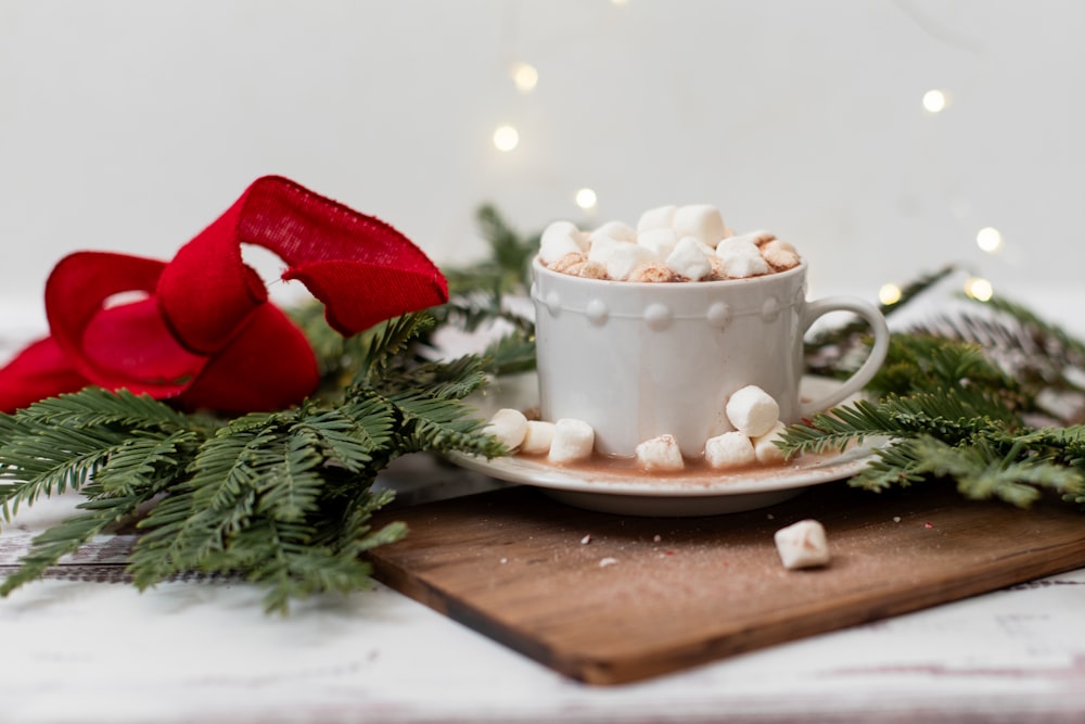 a cup of hot chocolate and marshmallows on a cutting board