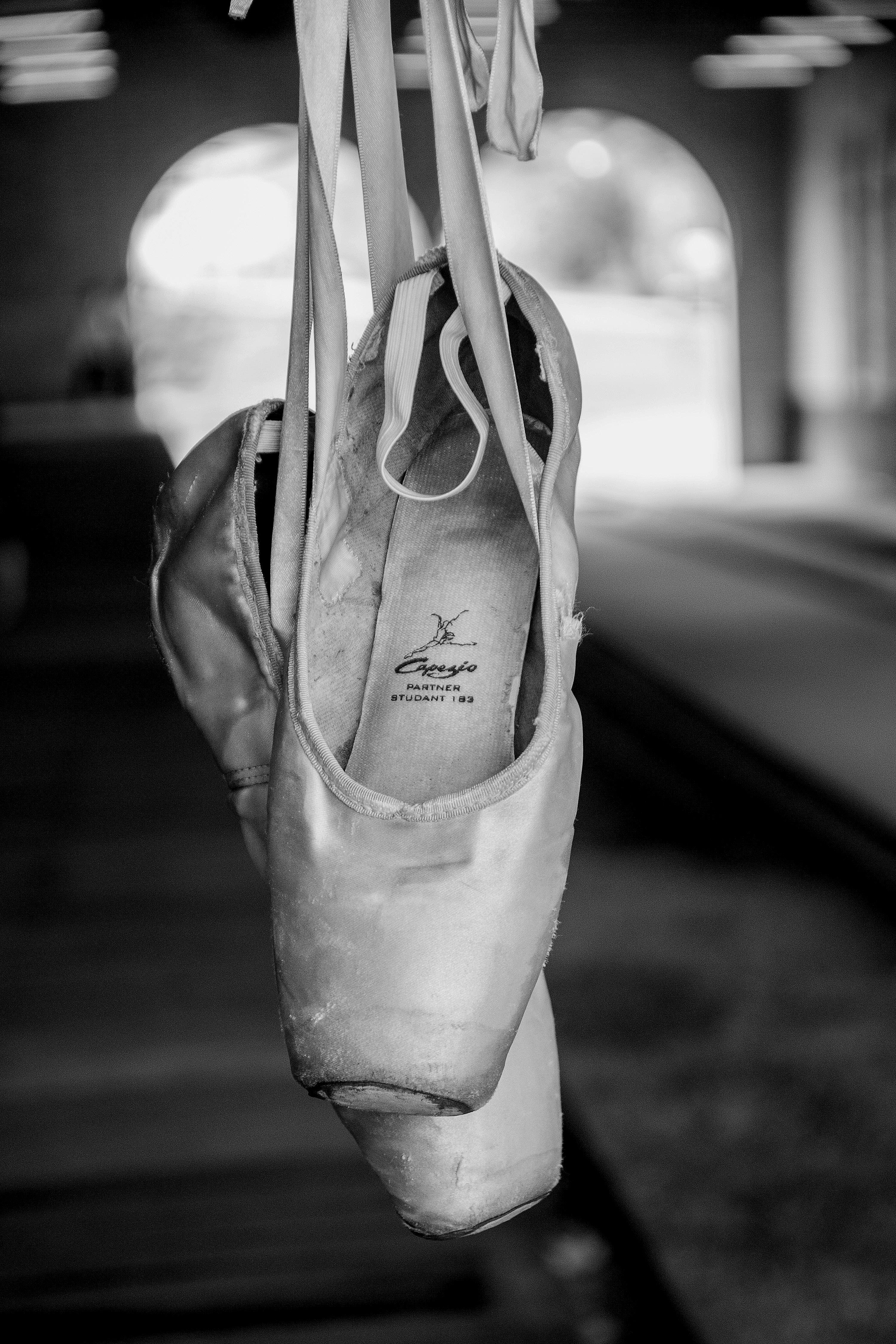 a pair of ballet shoes hanging from a line