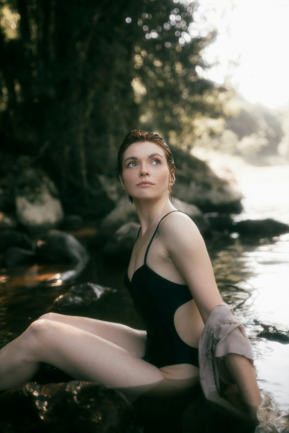 a woman in a bathing suit sitting in a river