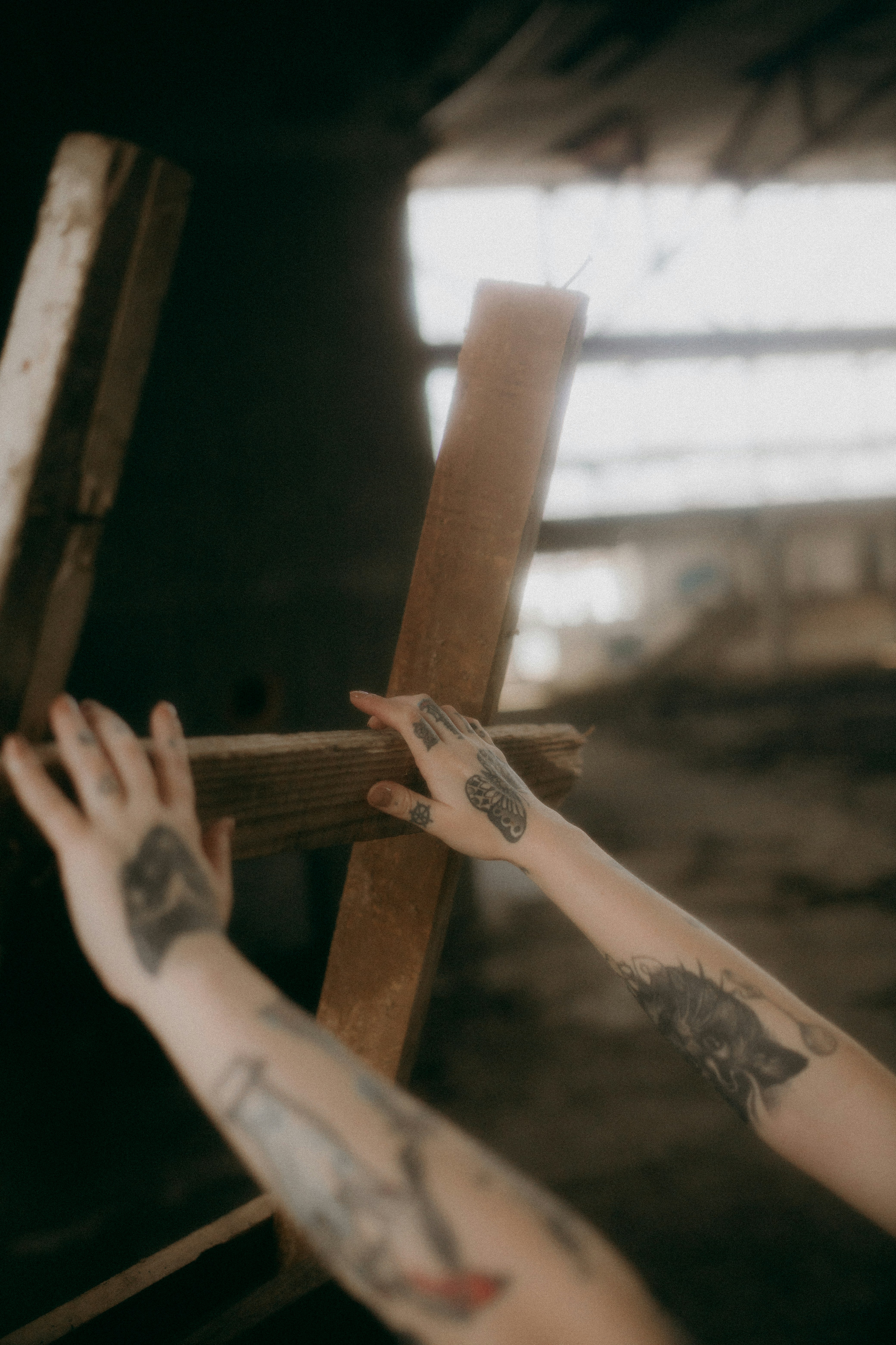 A close-up artistic shot highlighting Oak Journeys' strong hands and tattoo details against a soft brown backdrop.