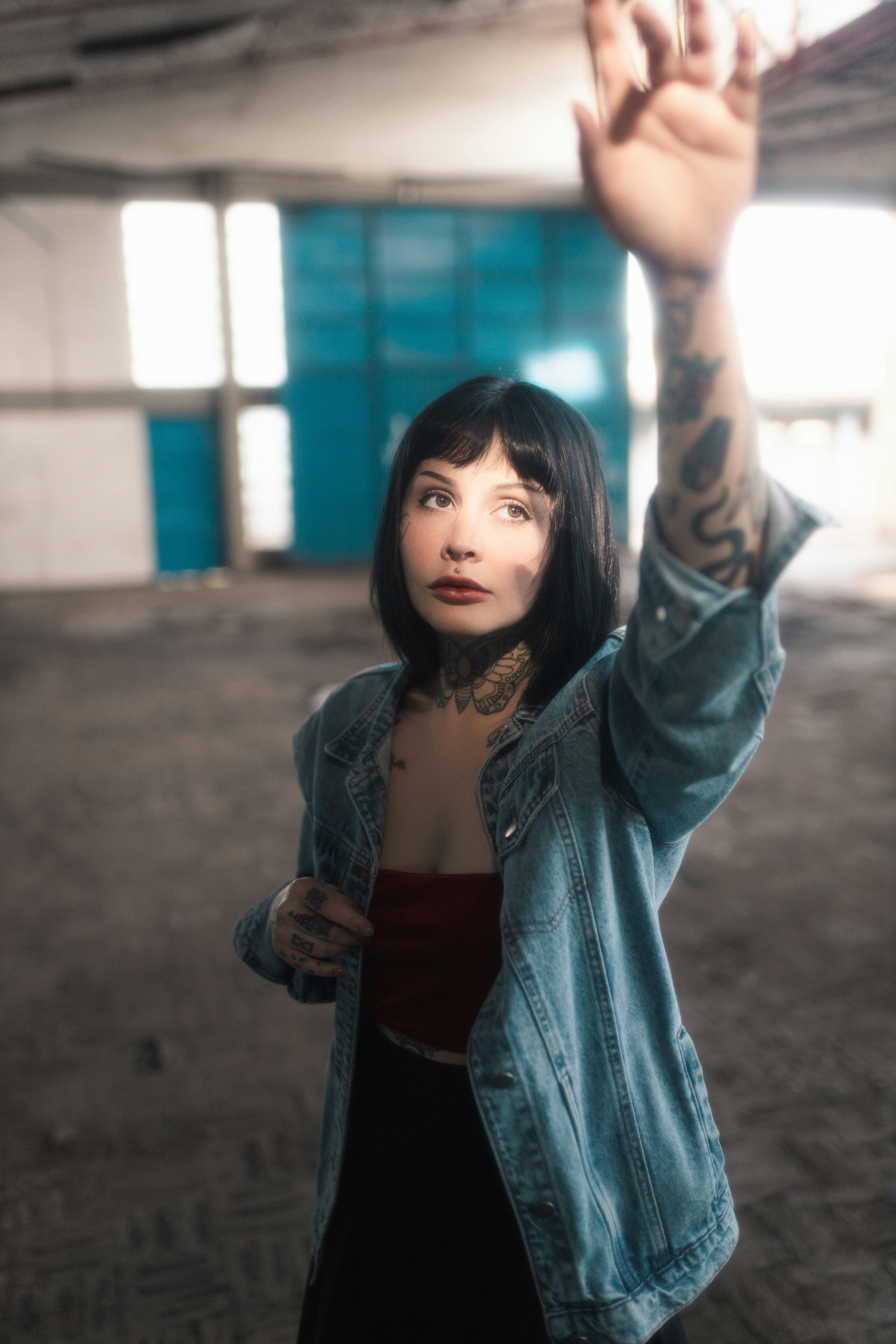 Seorang wanita dengan tato di lengannya mengangkat tangannya