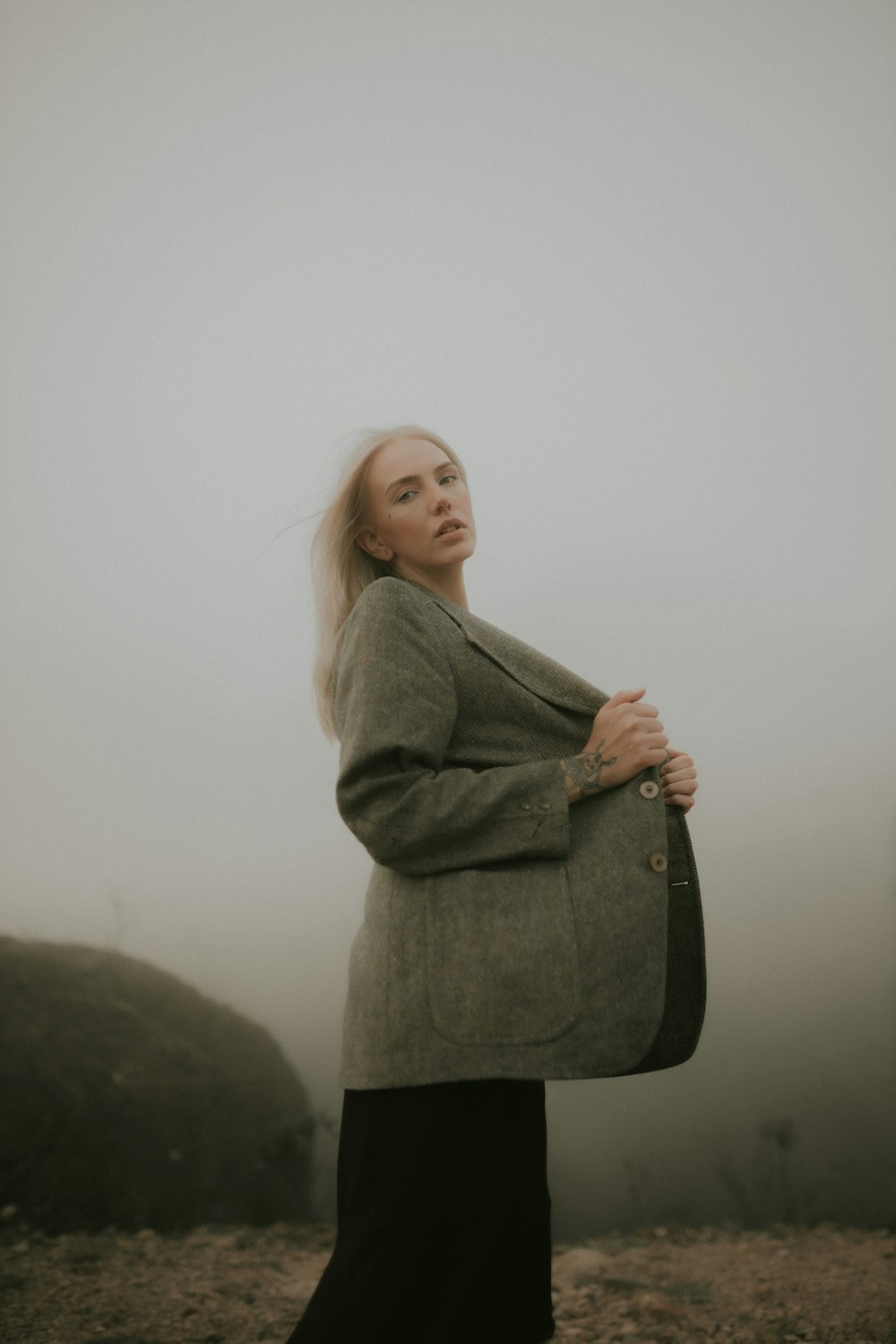una mujer de pie en la niebla con los brazos cruzados