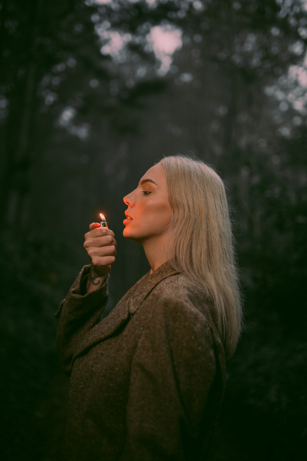 a woman holding a lit cigarette in her hand