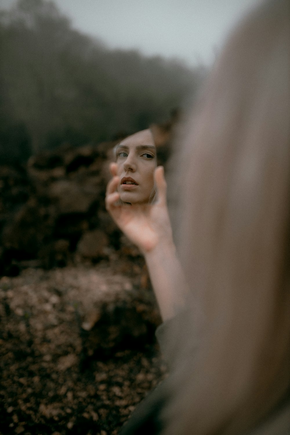 a woman holding her hand up to her face