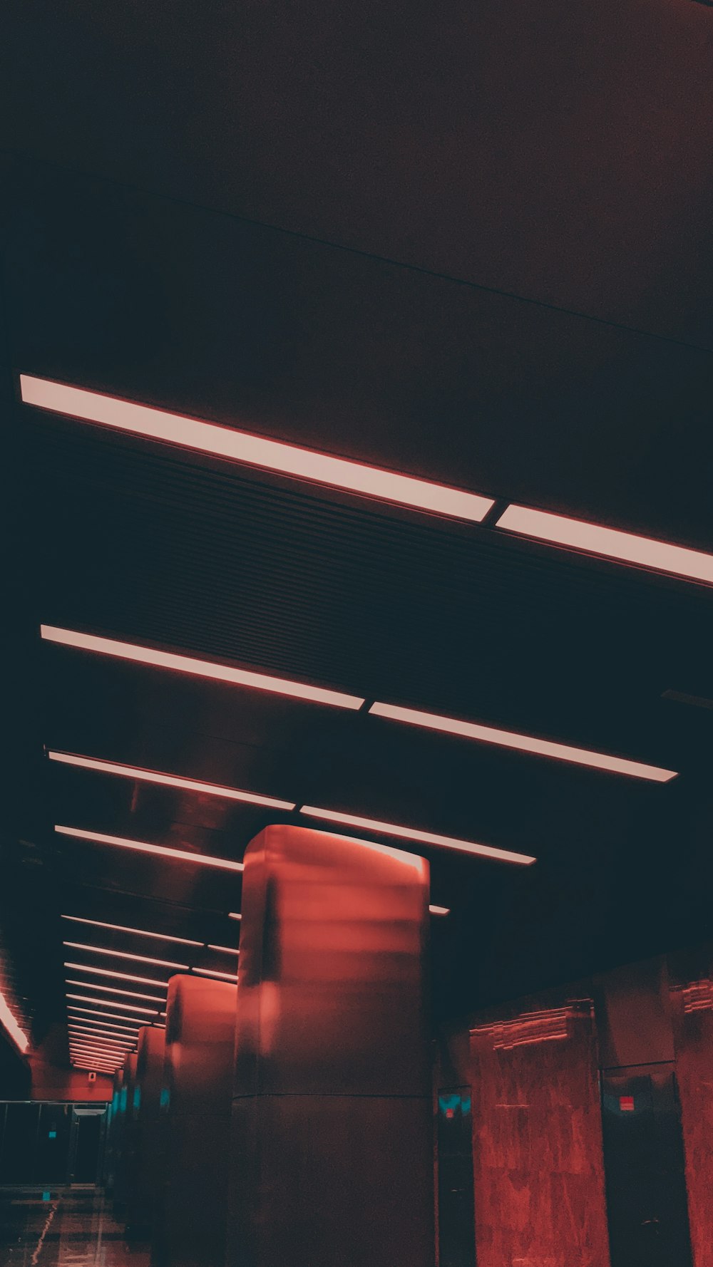 a long hallway with a red light coming from the ceiling