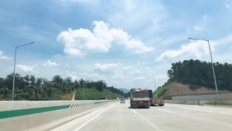 A modern truck on a highway under a clear blue sky.