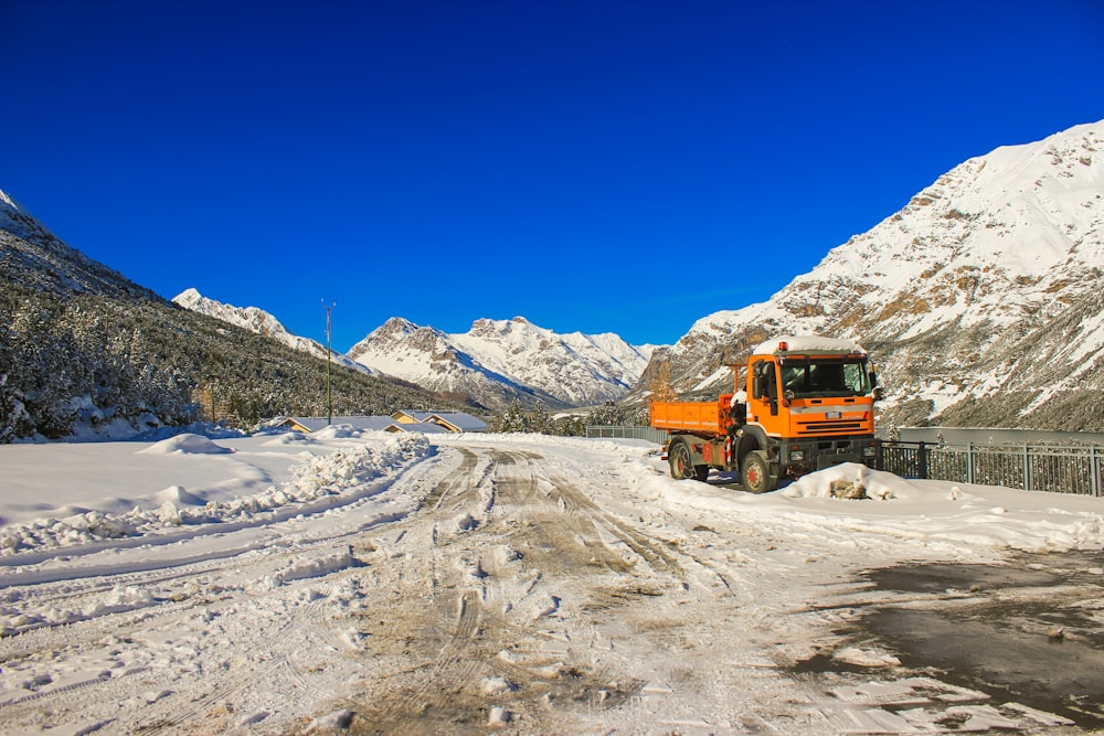 a large truck driving down a snow covered road