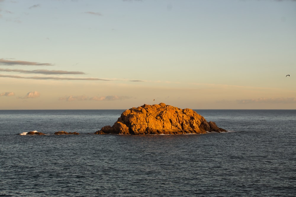 a large rock in the middle of the ocean