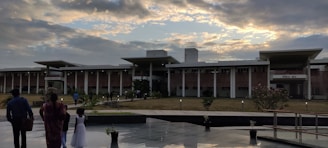 Dormitory building at sunset with students walking in courtyard.