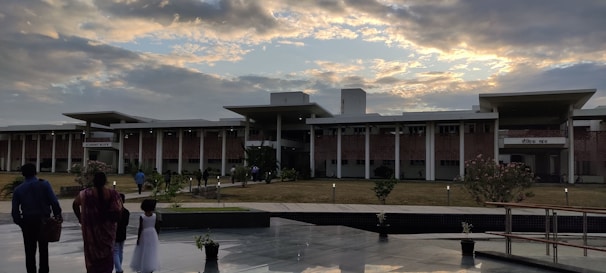 Dormitory building at sunset with students walking in courtyard.