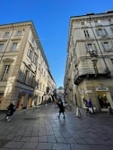 A scenic European city street with historic buildings and cobblestone paths.
