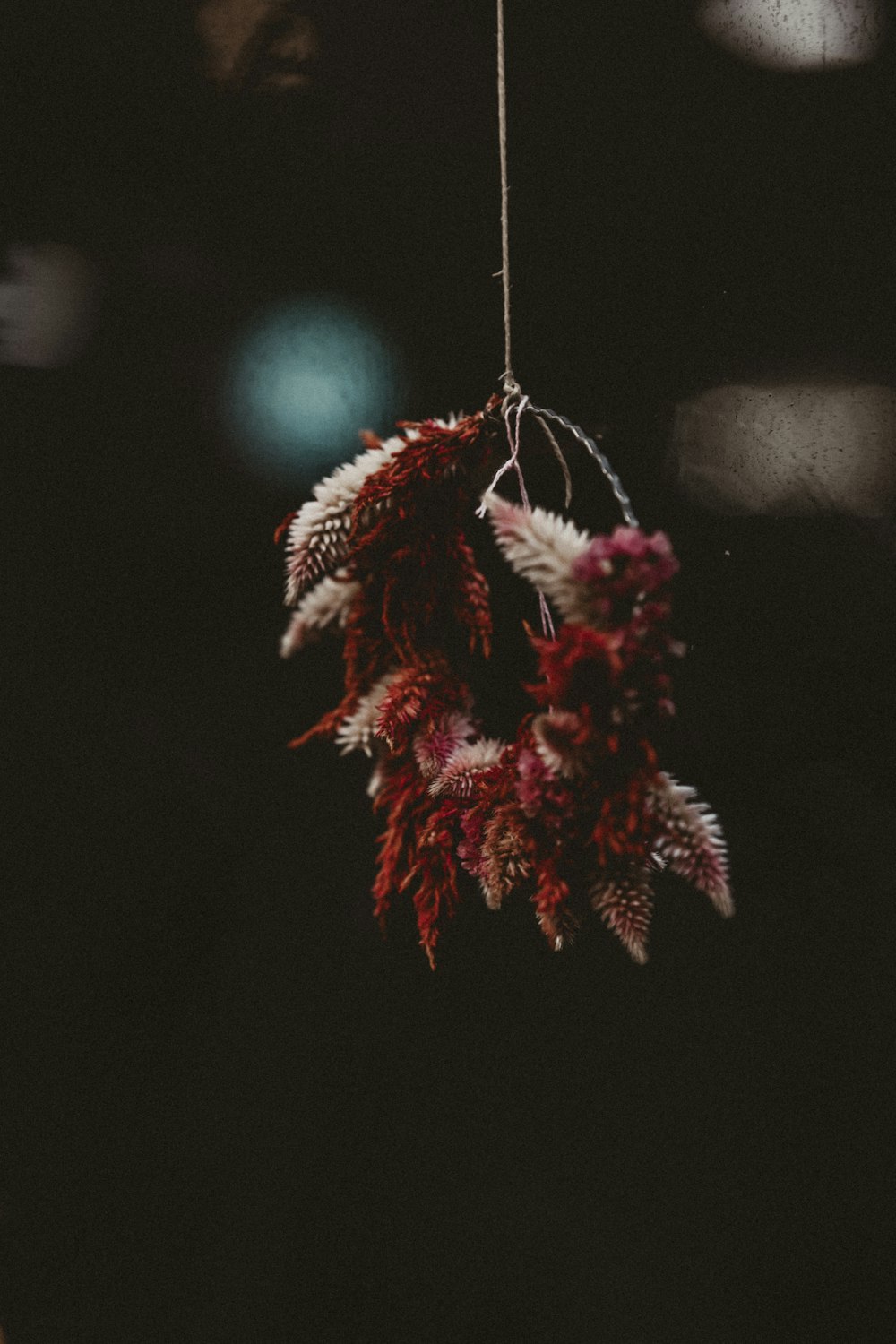 a red and white flower hanging from a string