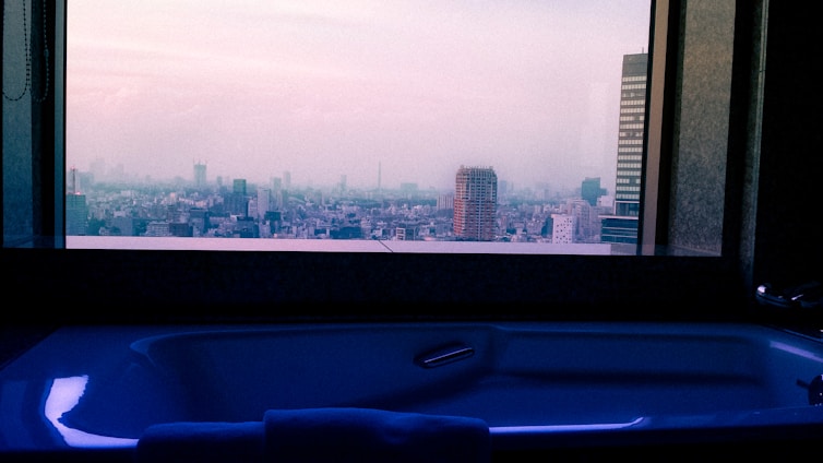 A skilled installer carefully fitting a custom bathtub in a bright, modern Louisville bathroom.