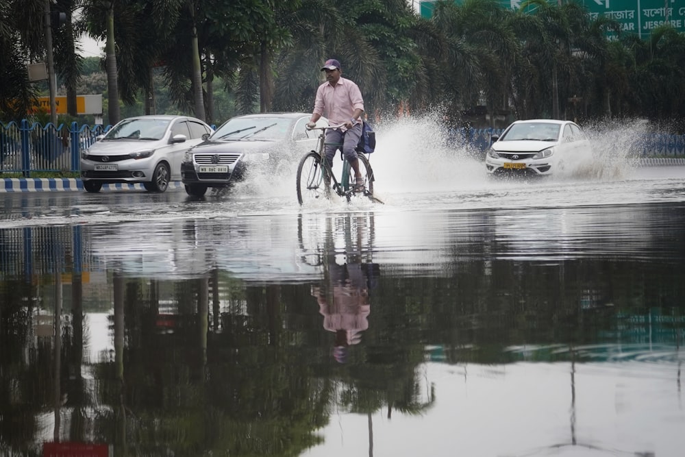 a man riding a bike through a flooded street