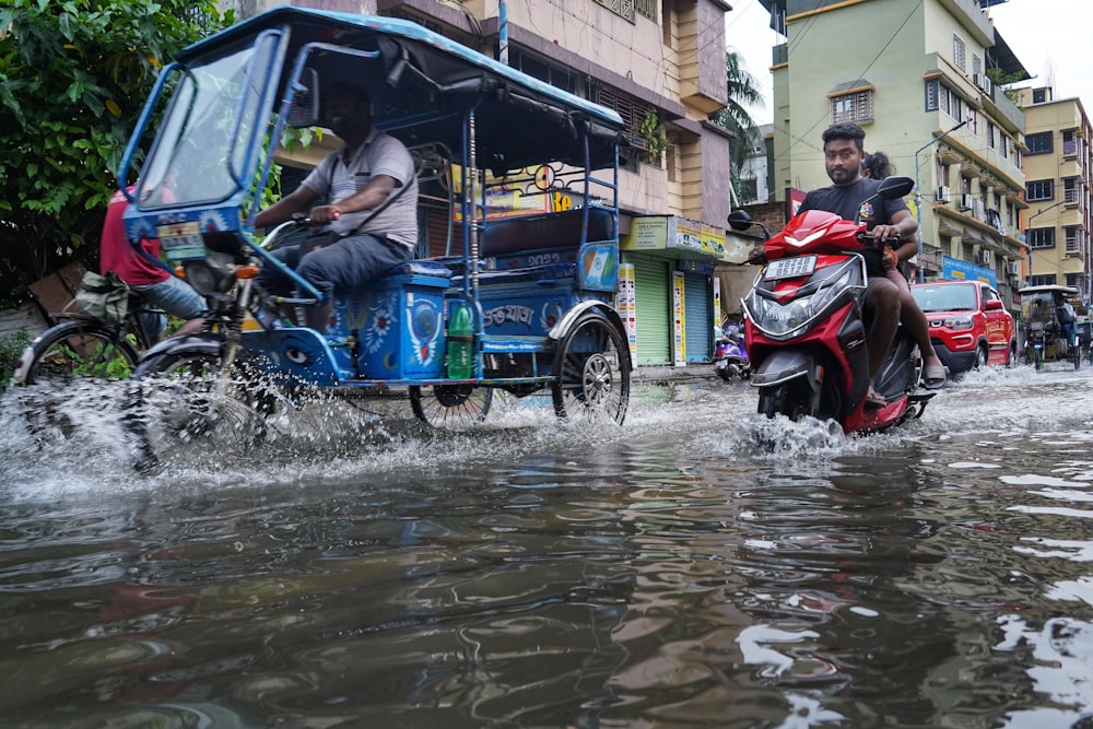 a man riding a motorcycle through a flooded street