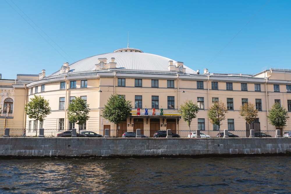 un grande edificio seduto accanto a uno specchio d'acqua