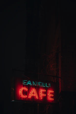 A bold signboard with clear, crisp lettering advertising a local café, mounted outside a shop.