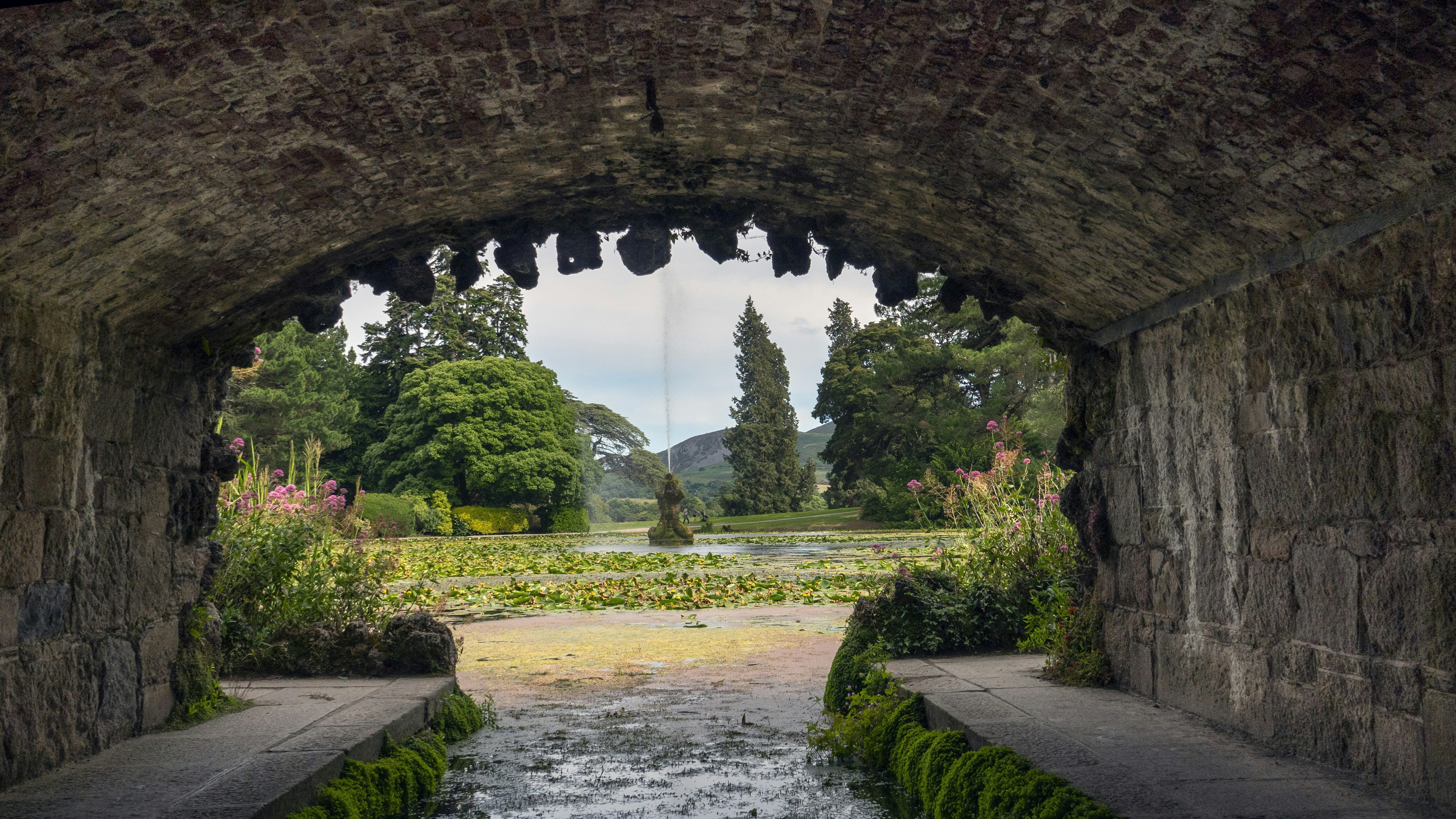 a stone tunnel with a stream running through it