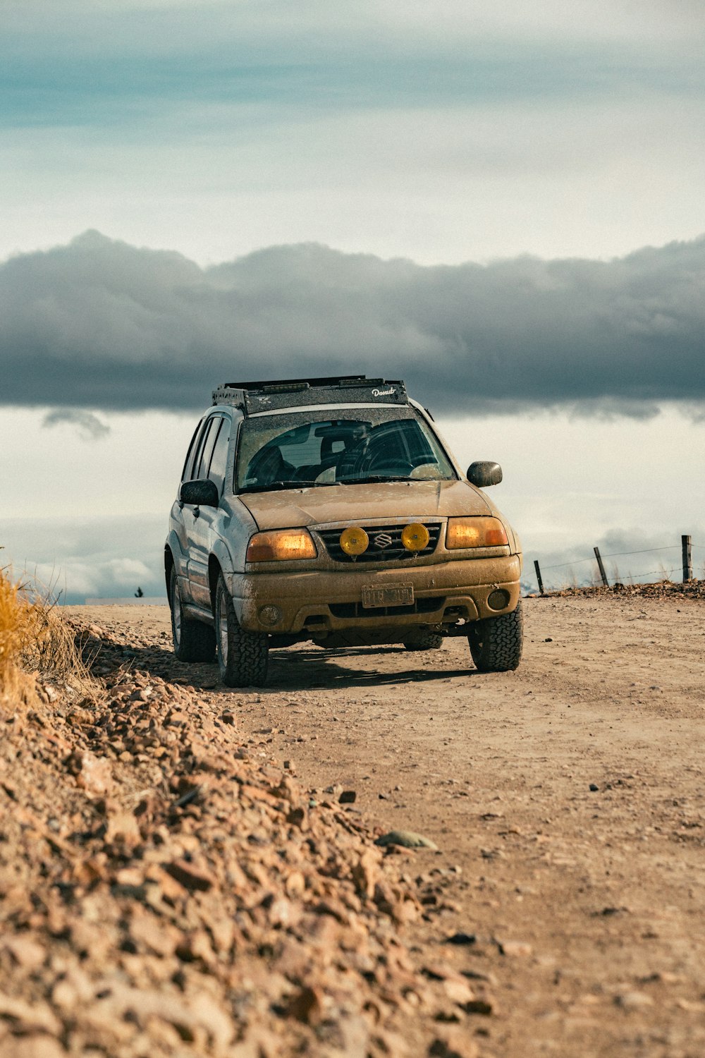 a car driving down a dirt road in the desert