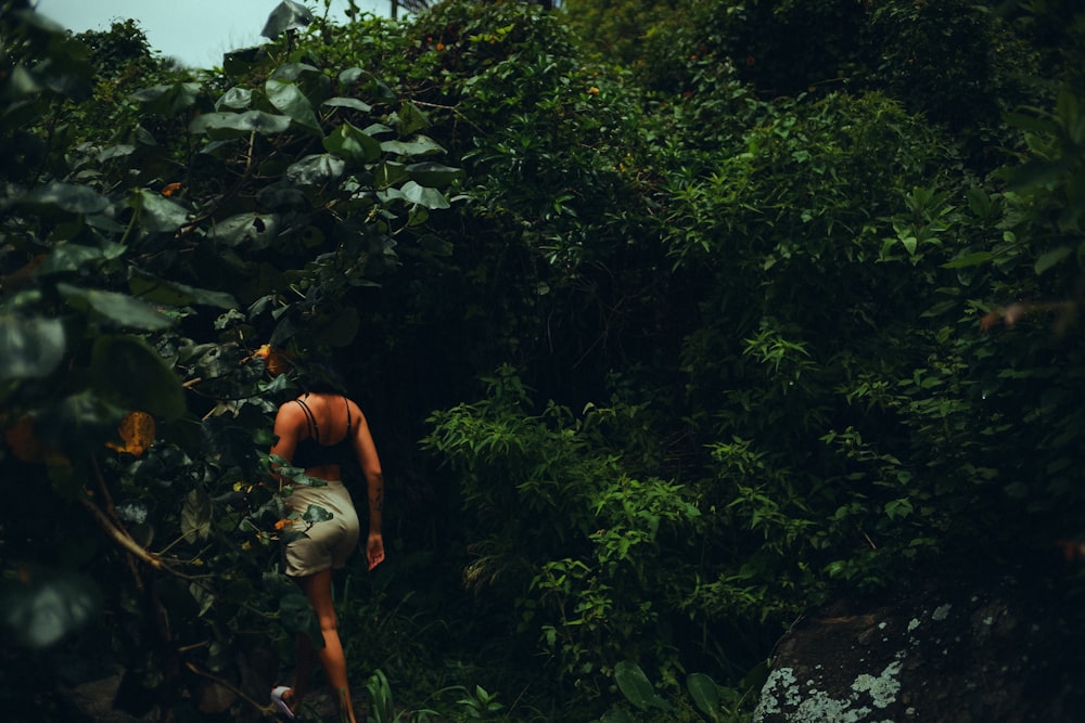 a man standing in the middle of a lush green forest