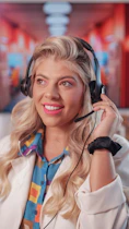 a woman wearing headphones and smiling at the camera