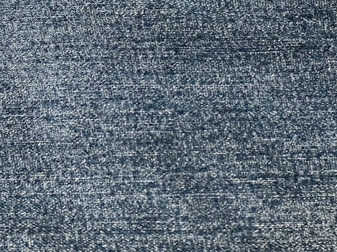 A close-up view of a textured fabric, showing a pattern of tightly woven threads with a consistent blue tone.