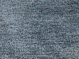 A close-up view of a textured fabric, showing a pattern of tightly woven threads with a consistent blue tone.