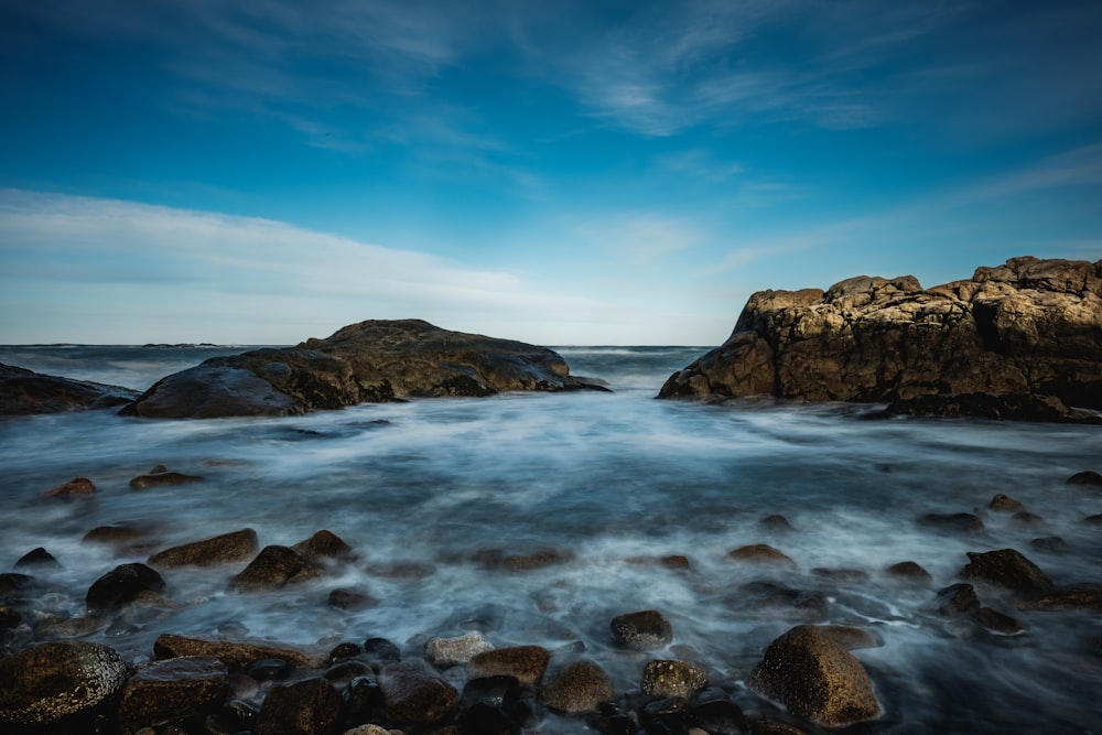 a rocky beach with a body of water