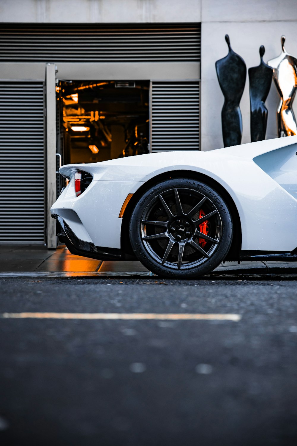 a white sports car parked in front of a building