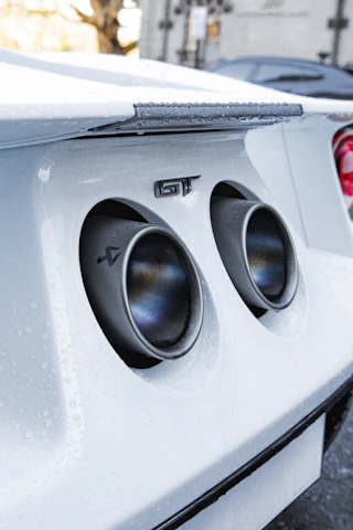 Valved exhaust system installed on a sporty car, emphasizing sleek pipes and controls.