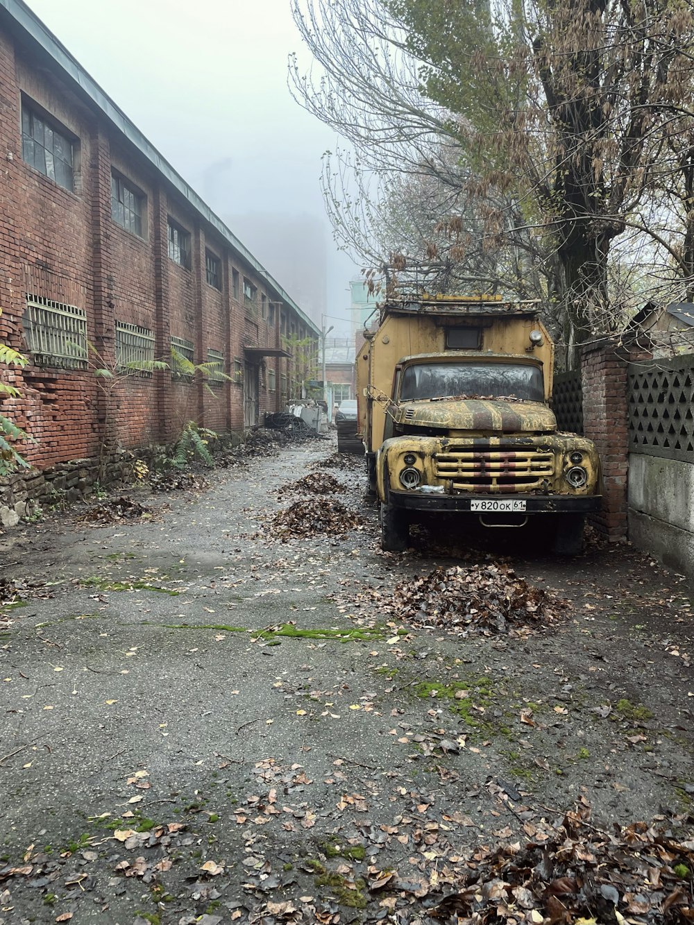 a yellow truck parked next to a brick building