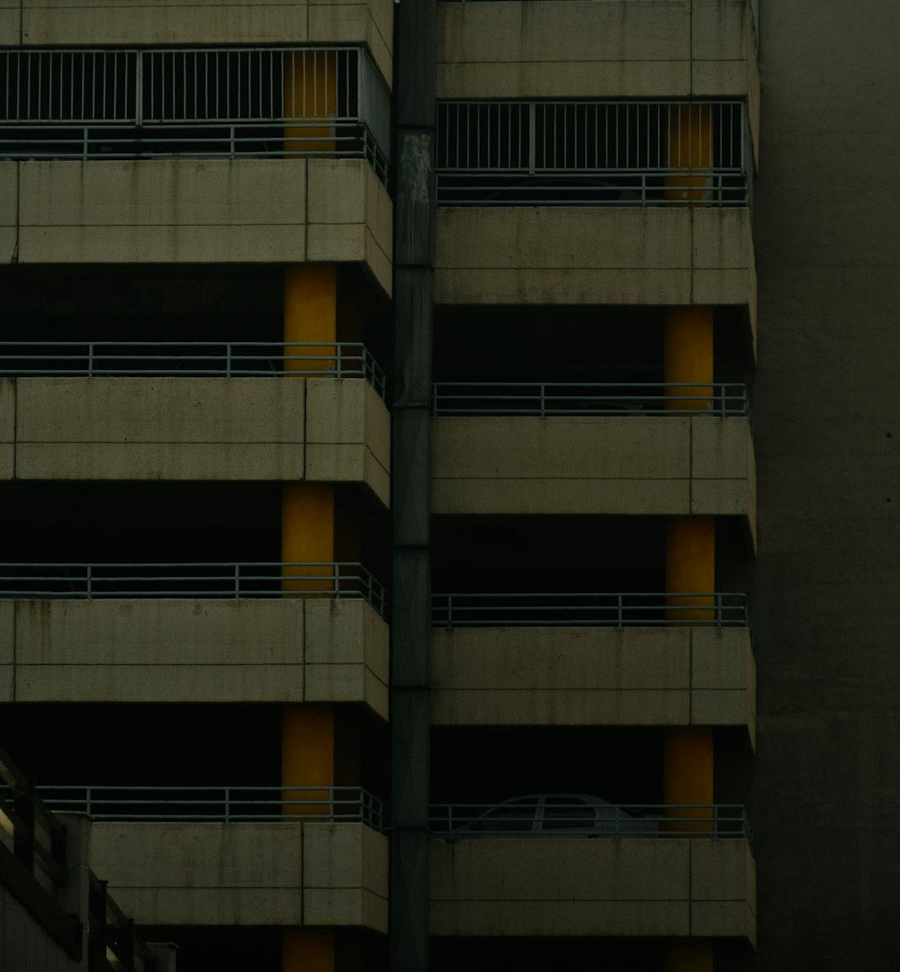 a tall building with balconies and yellow balconies