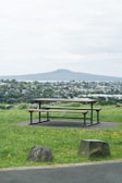 a park bench sitting on top of a lush green field