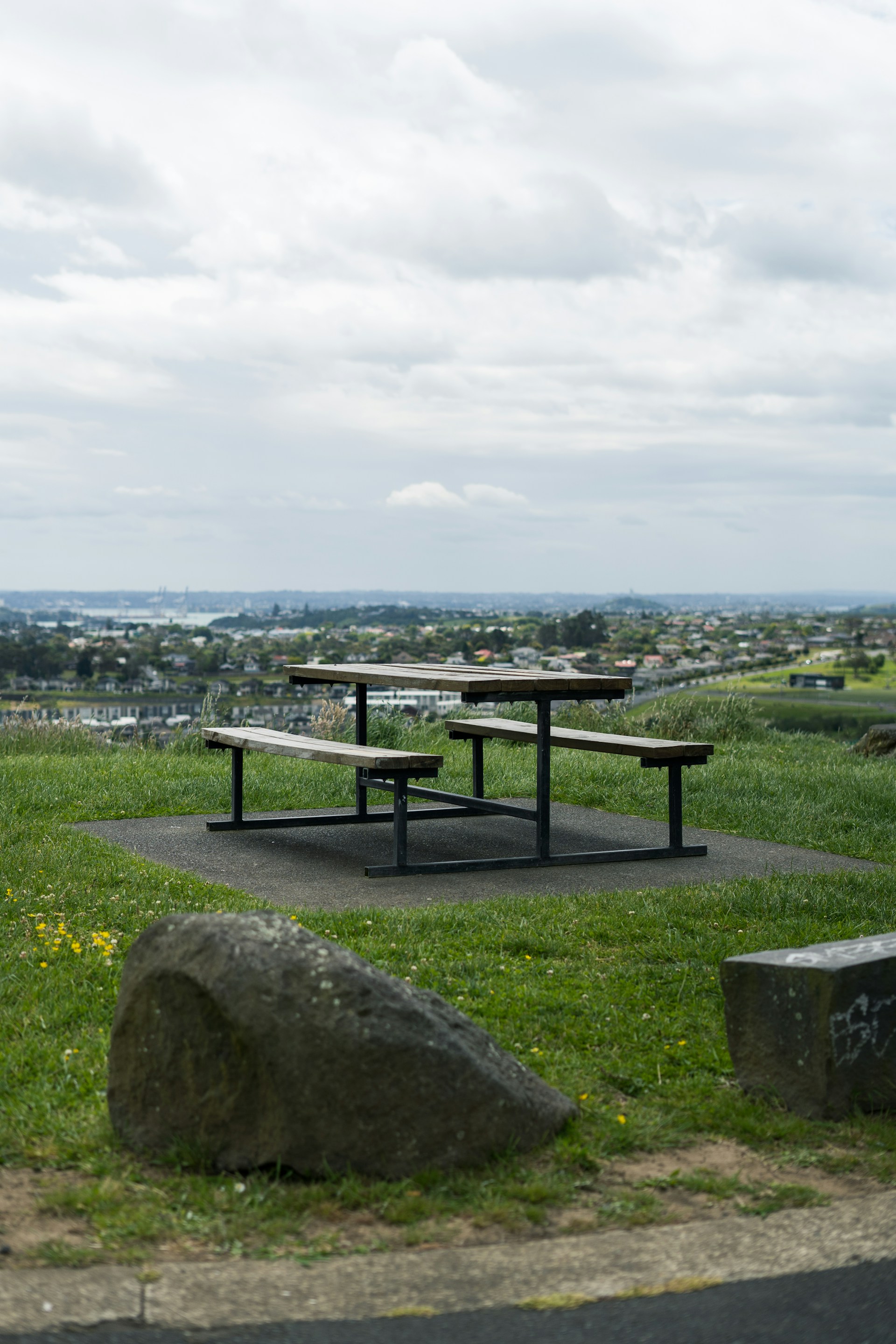 A cozy family picnic set up on a grassy hillside with colorful wildflowers and panoramic views of a Colorado sunset.