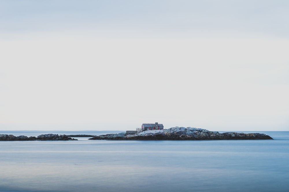 a lighthouse on a small island in the middle of the ocean