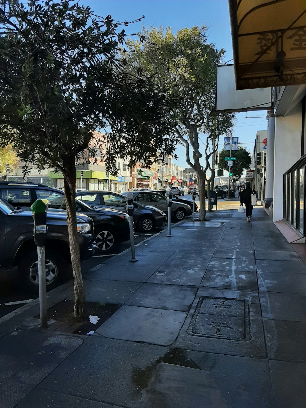 a man walking down a sidewalk next to a parking meter