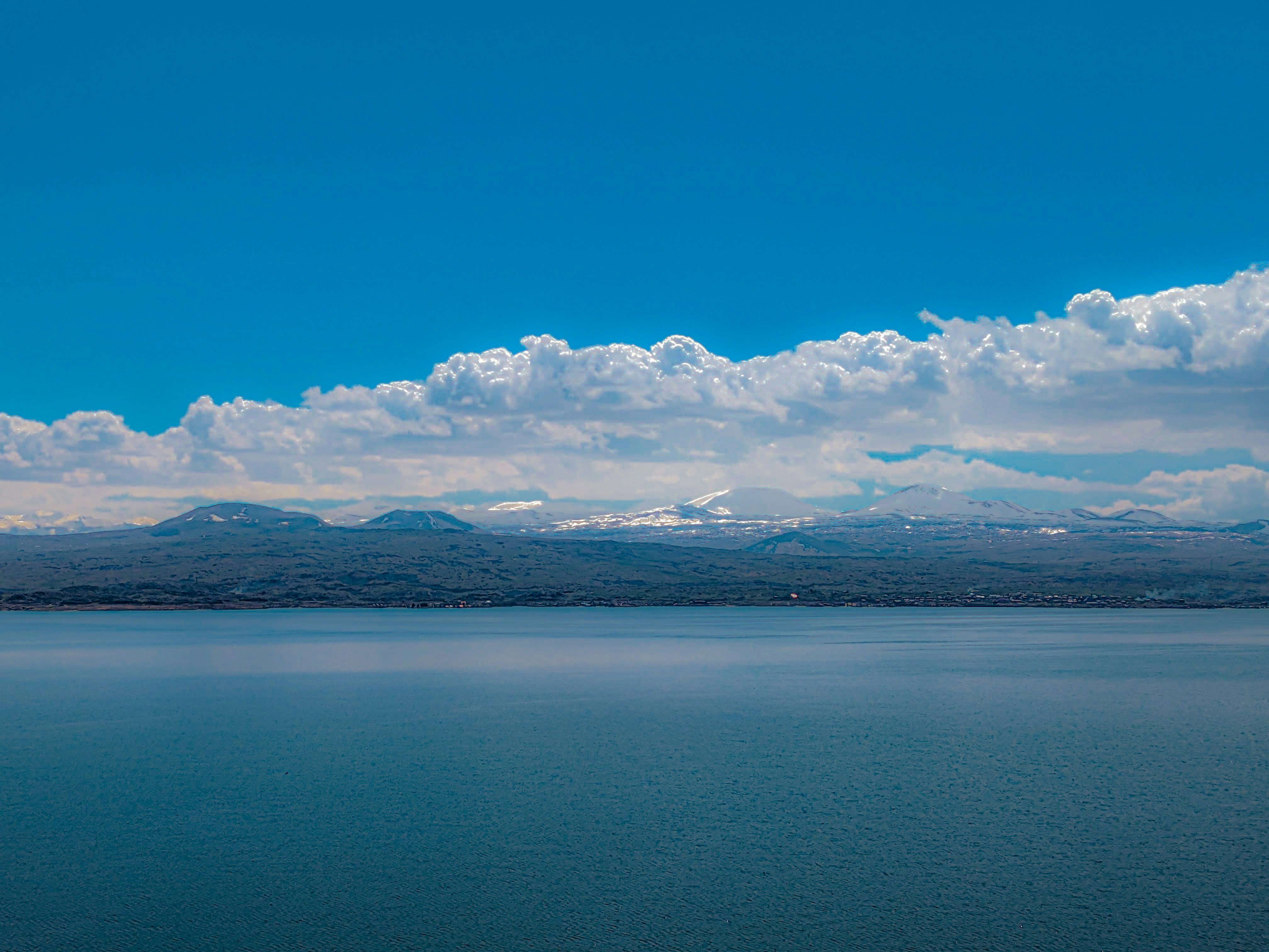a large body of water with mountains in the background, 
