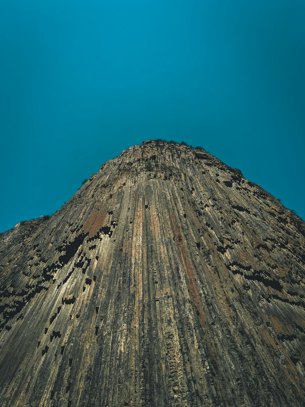 uma formação rochosa muito alta com um céu azul ao fundo