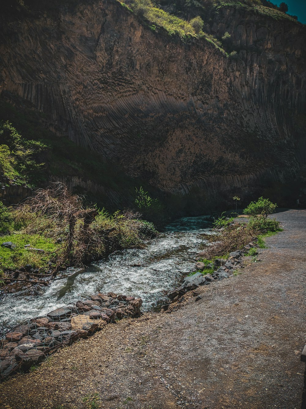 a man sitting on a bench next to a river