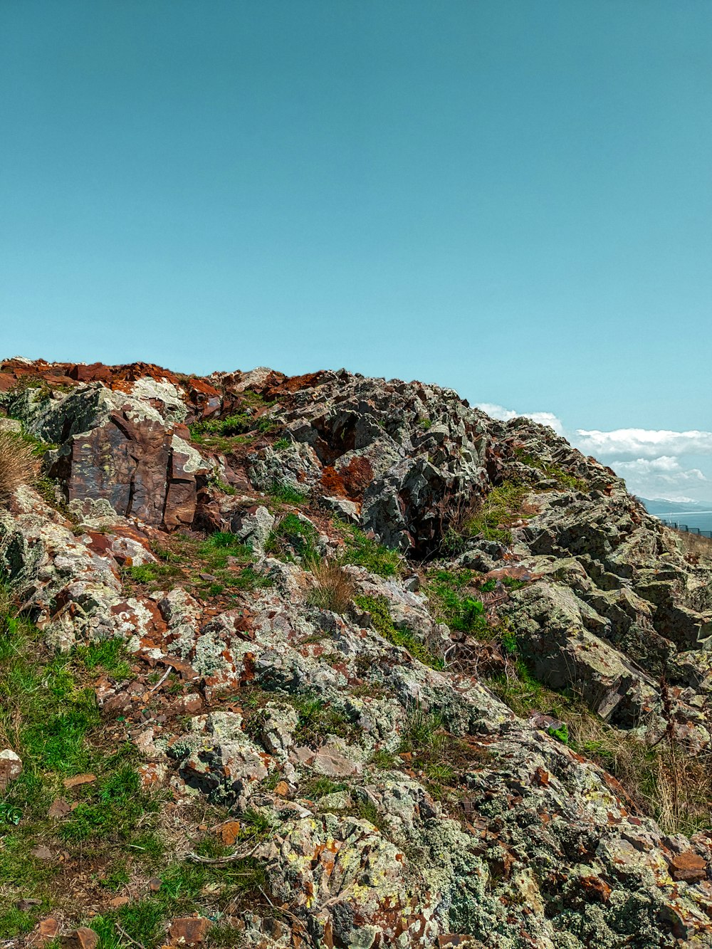 a rocky hill with grass and rocks on it