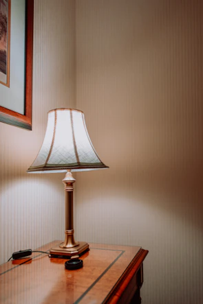 Light luxury marble table lamp glowing gently on a wooden side table.