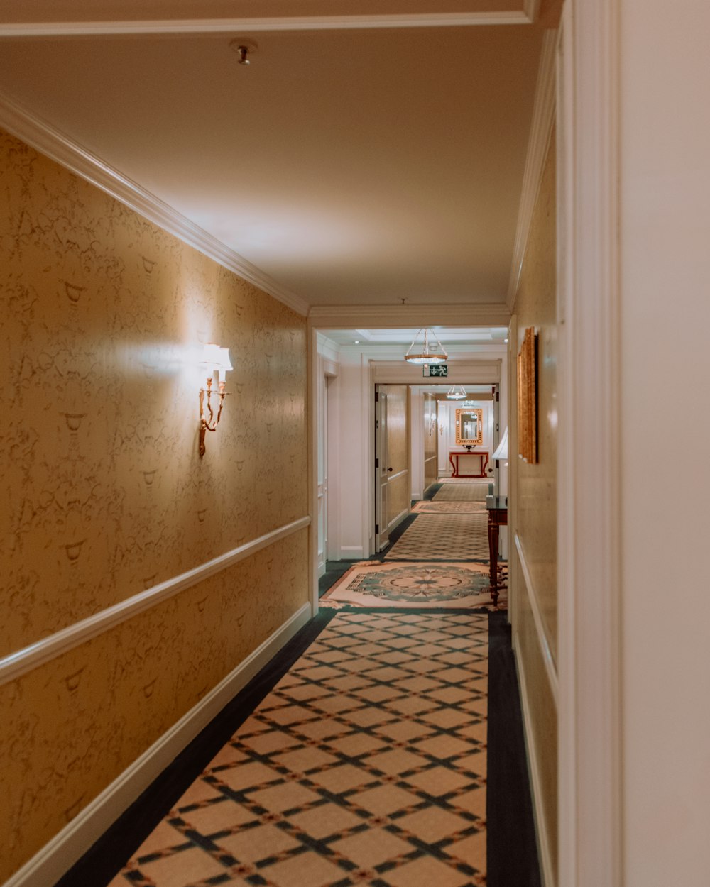 a long hallway with a checkered floor and wallpaper