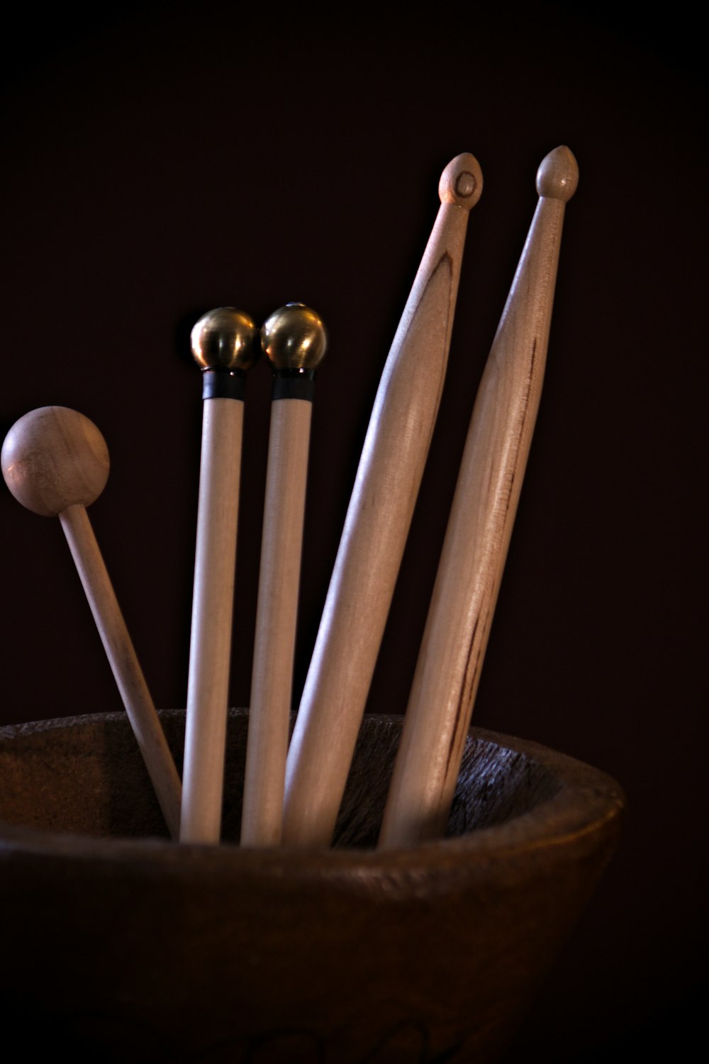 a wooden bowl filled with wooden spoons and wooden mallets