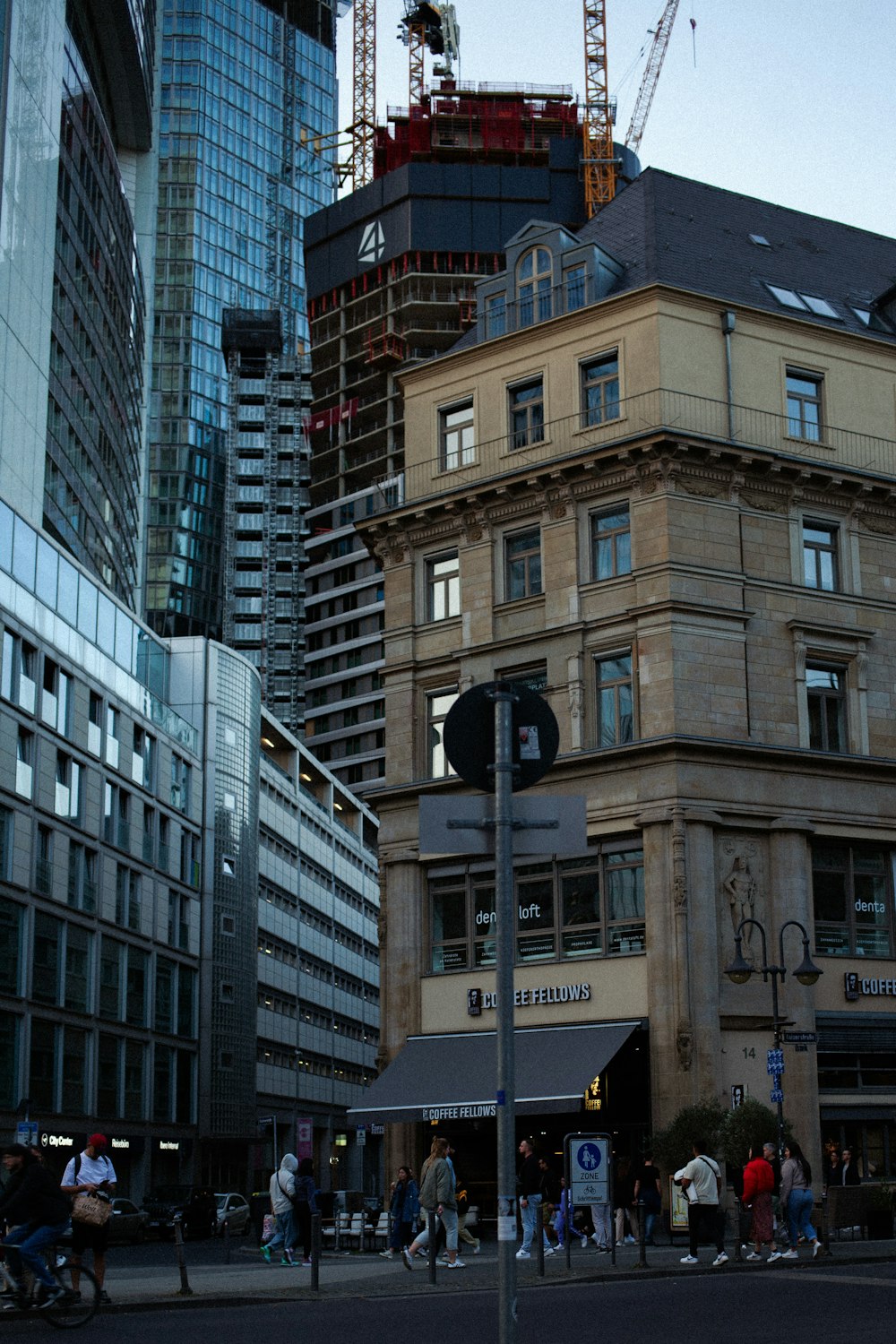 a group of people walking down a street next to tall buildings